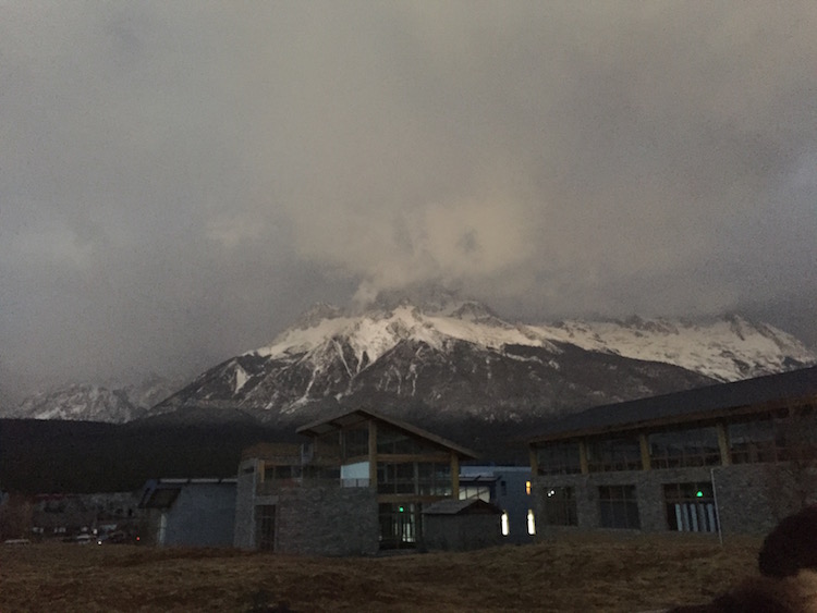 排队等景区内大巴时拍的晨霭中的玉龙雪山